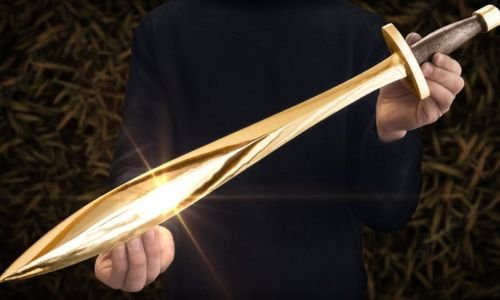 A person holds a  Xiphos golden sword that emits a bright light, illuminating their surroundings with a warm glow.